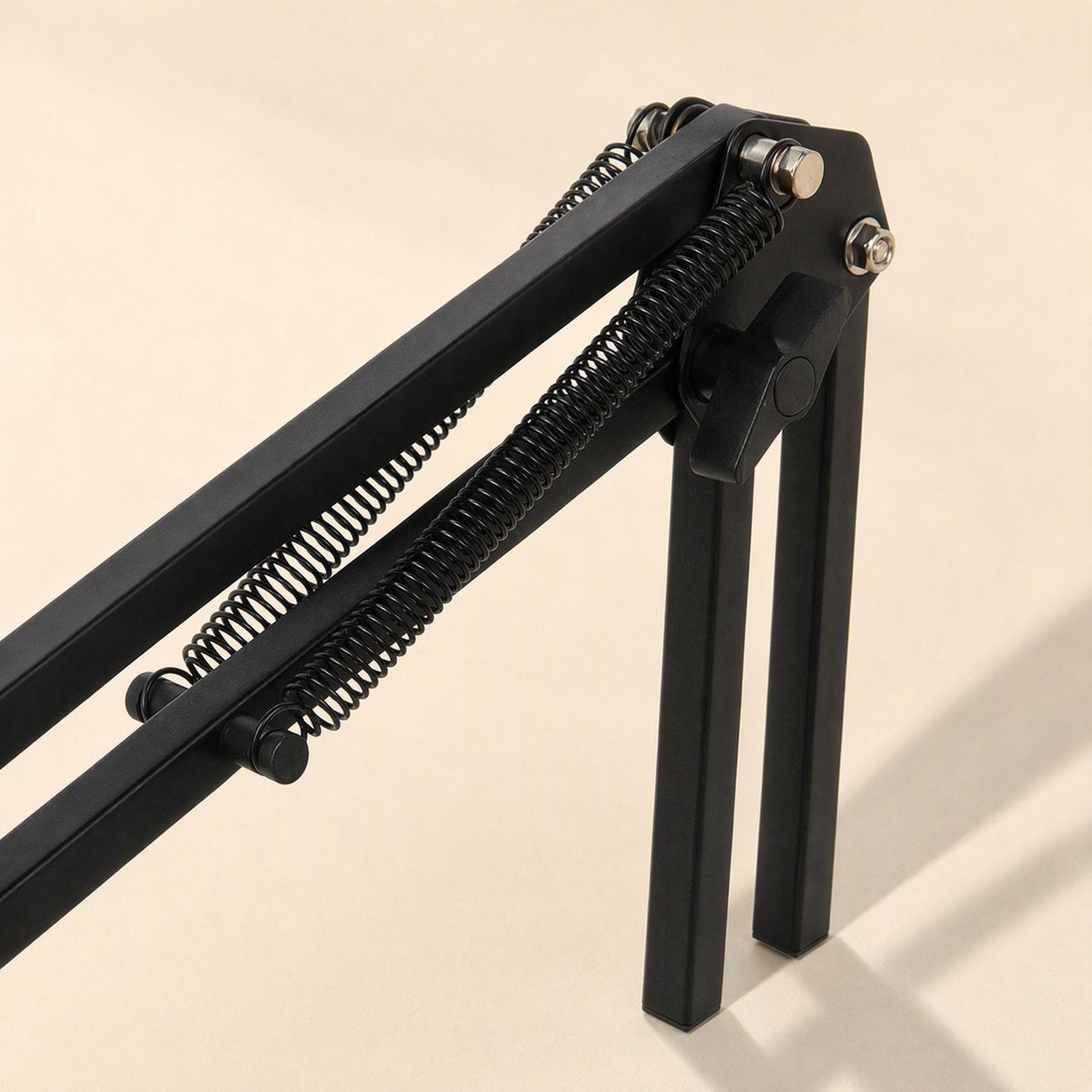 Phonebrace – Close-up of the bracket's coiled springs, knob joint and two black legs on a beige background