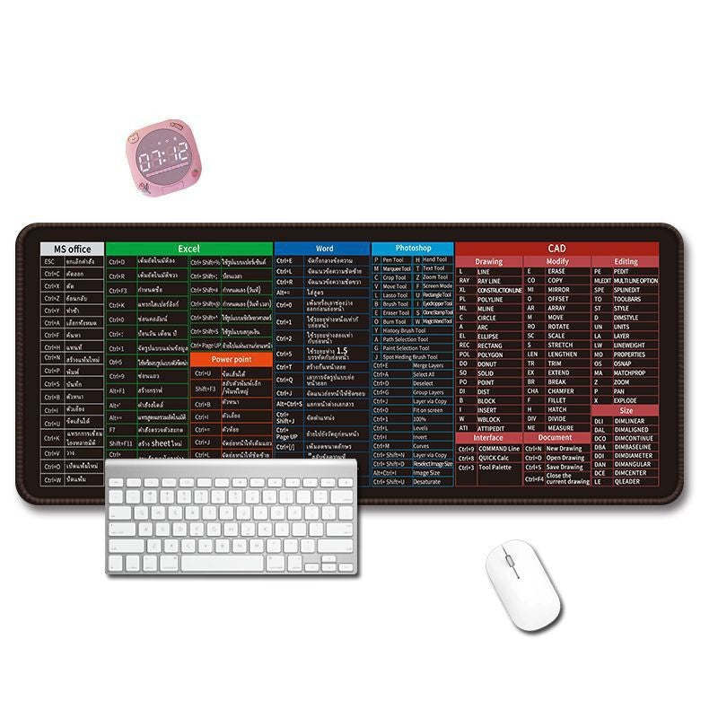 Braxwell – Long black shortcut-key mouse pad on a desk with a white keyboard, mouse and small pink clock