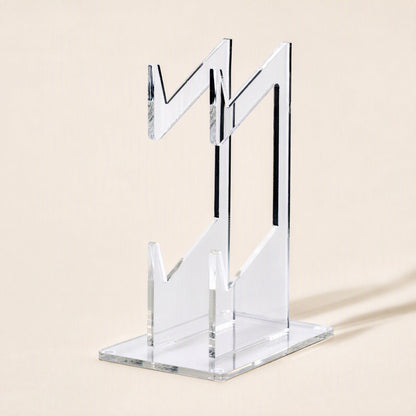 Padstand – Rear three-quarter view of the clear acrylic stand showing the zigzag cradle arms and flat base