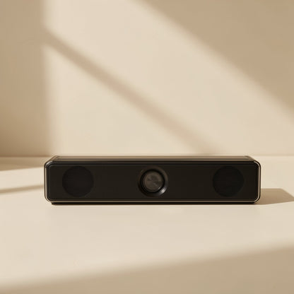 Deskbeat – Black soundbar-style speaker seen straight on, with two round grilles and a center knob on a cream surface