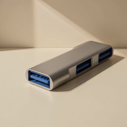 Docklink – Close-up of the hub's blue USB-A ports on a silver aluminum body resting on a cream surface