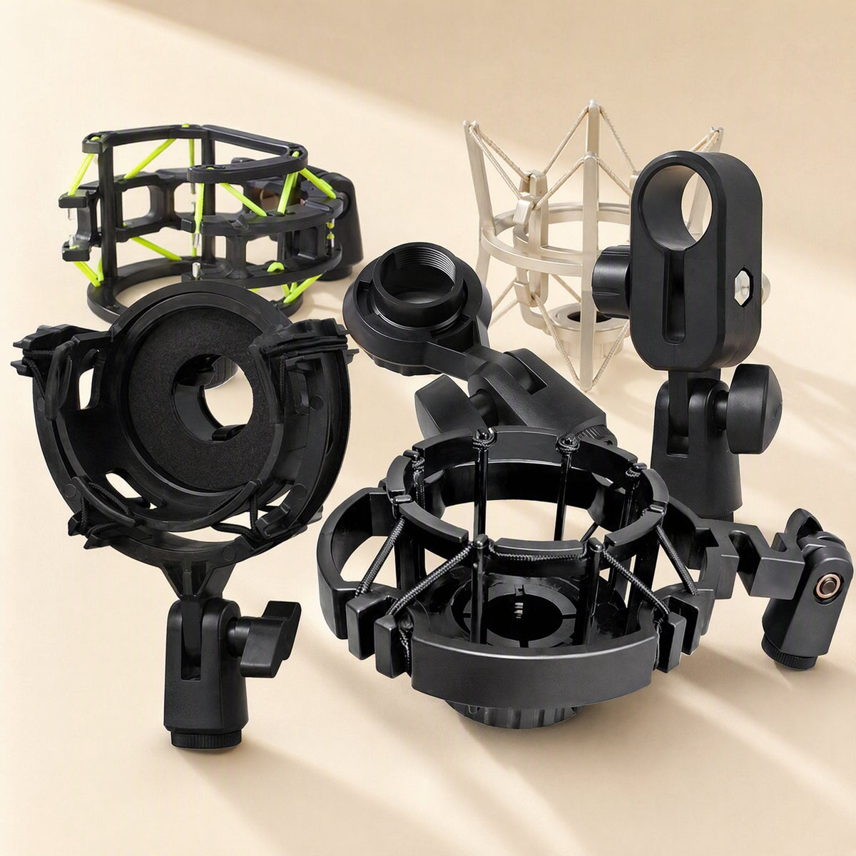 Shockgrip Microphone Shock Mount in several black and one silver style, grouped on a beige background