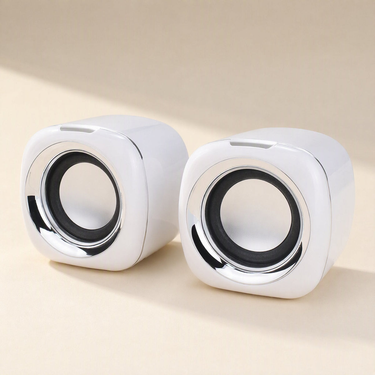 Deskvoice USB Computer Desktop Speaker pair in white with chrome-ringed drivers on a beige tabletop