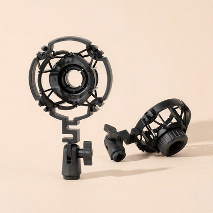 Calmstand – Two black plastic shock mounts, one upright with a ball-joint clamp and one tilted, on a peach background