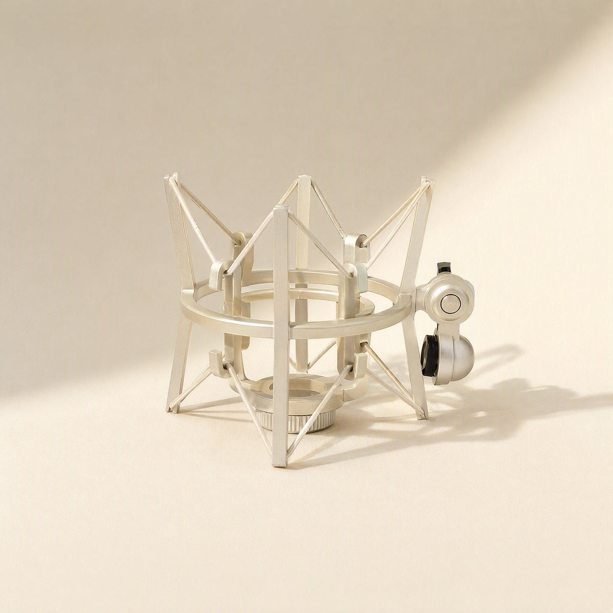 Calmstand – Silver metal shock mount with a spider-style frame and side ball-joint adapter against a cream backdrop