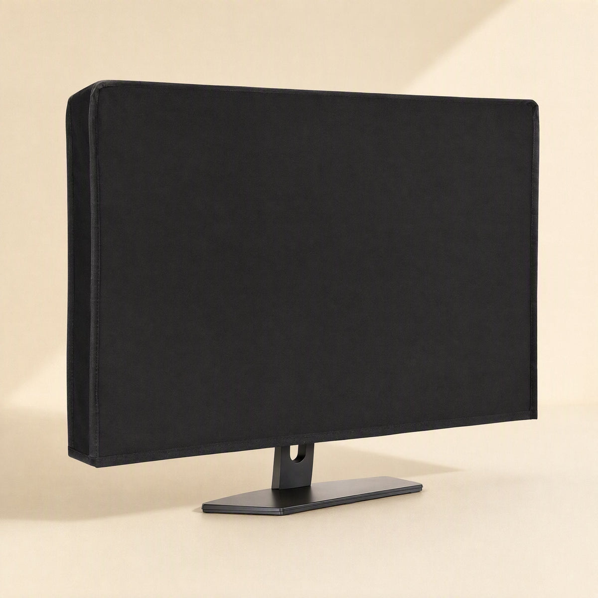 Coverloom Monitor Dust Cover – black fabric cover on a desktop monitor, three-quarter view showing the stand's base