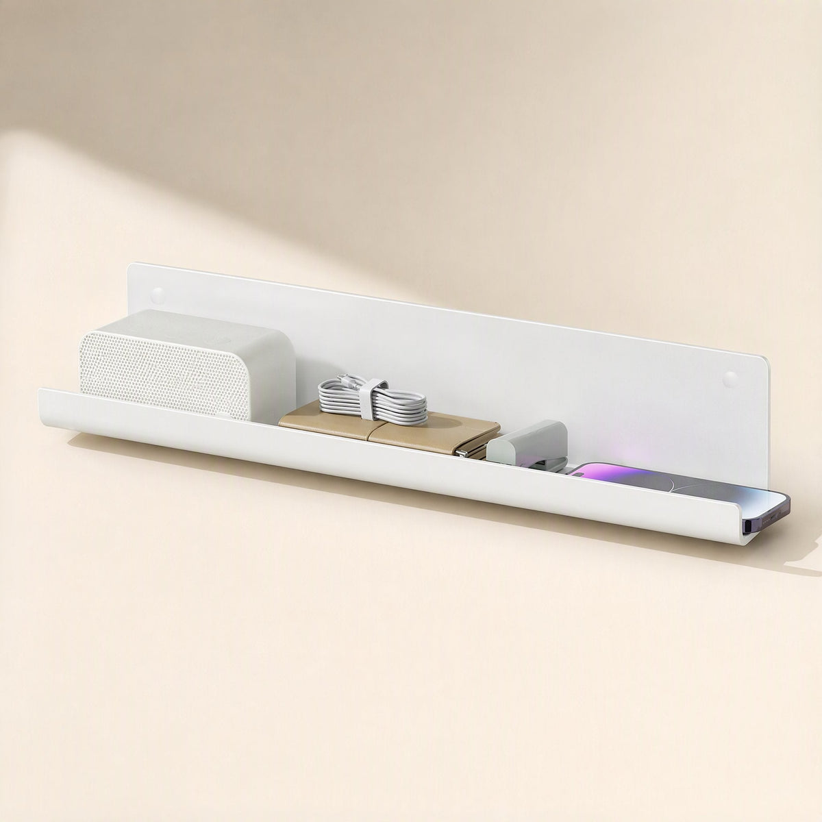 Wireledge PVC Under-Table Wire Management Rack mounted on a wall holding a speaker, cables and a phone