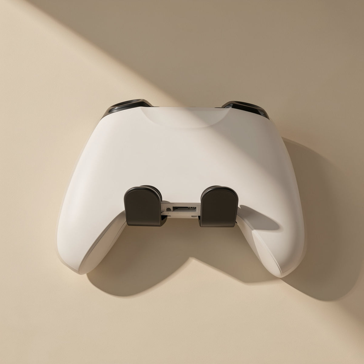 Padperch ABS Game Controller Stand – back of a white controller resting on two black stand arms against a beige wall