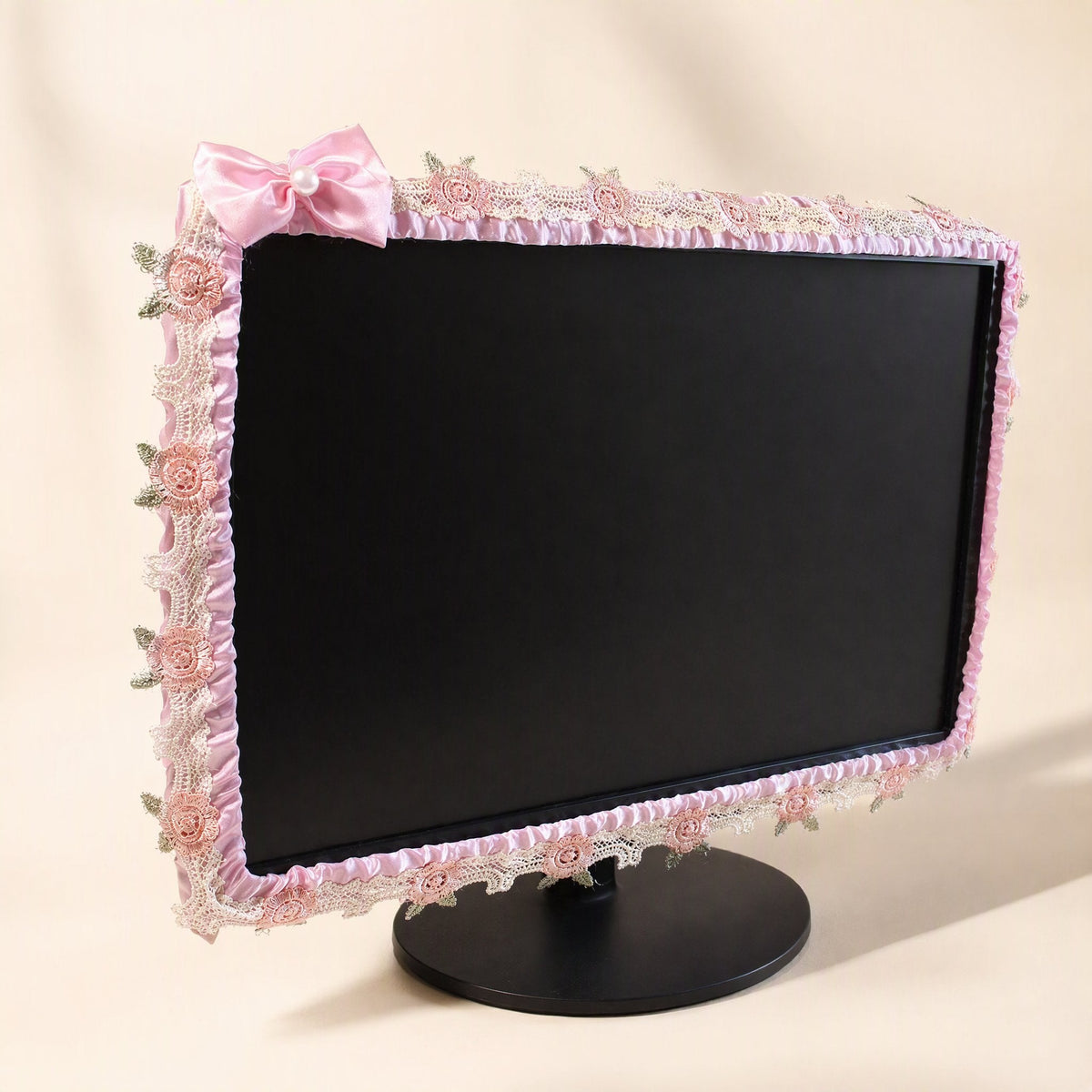Silkdrape – Pink satin monitor cover with lace rose trim and a pale pink bow, shown from a slight angle on a black stand