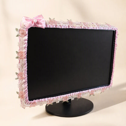 Silkdrape – Pink satin monitor cover with lace rose trim and a pale pink bow, shown from a slight angle on a black stand