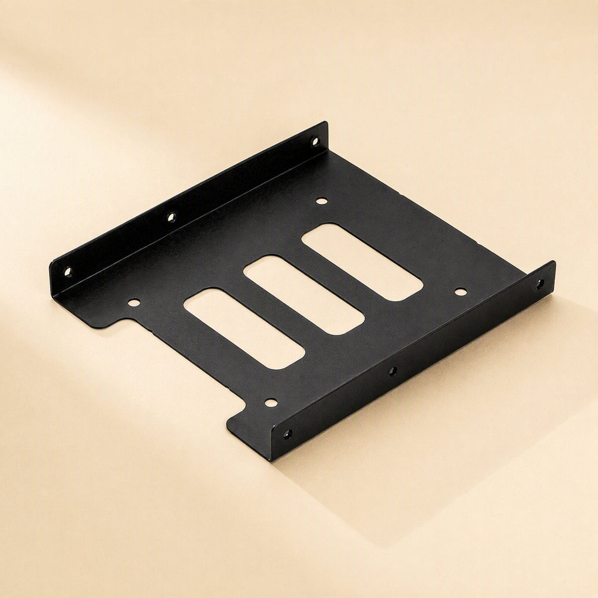 Diskfit – Black metal bracket with three slotted cutouts and screw holes, seen at an angle on a beige background