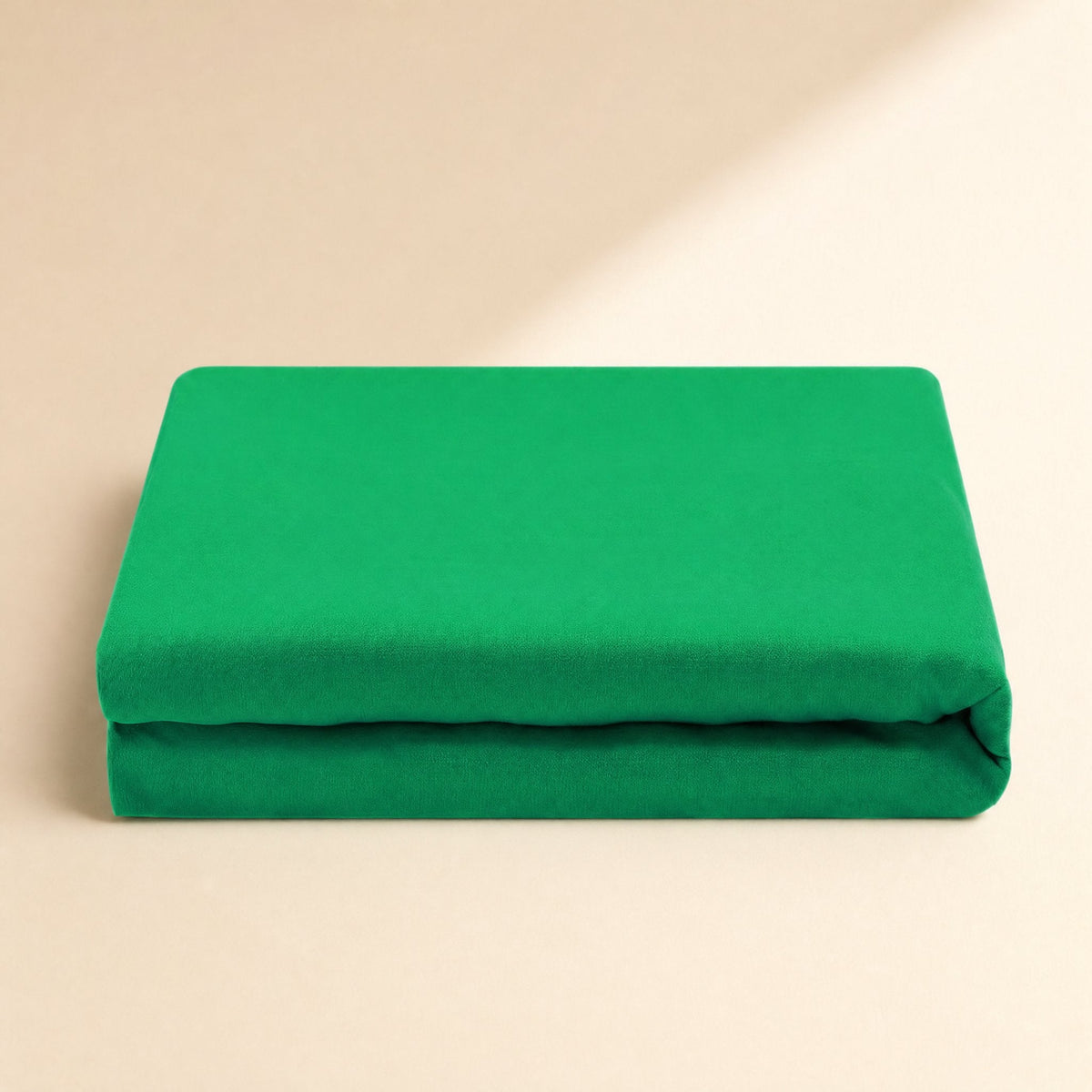 Screenweave – Green background cloth folded in thick layers, shown from the side on a cream backdrop