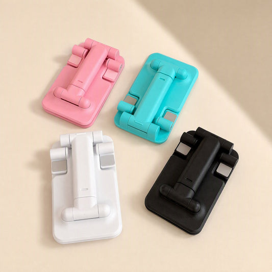 Pocketfold – Four folded phone stands in pink, teal, white and black on a cream surface, seen from above