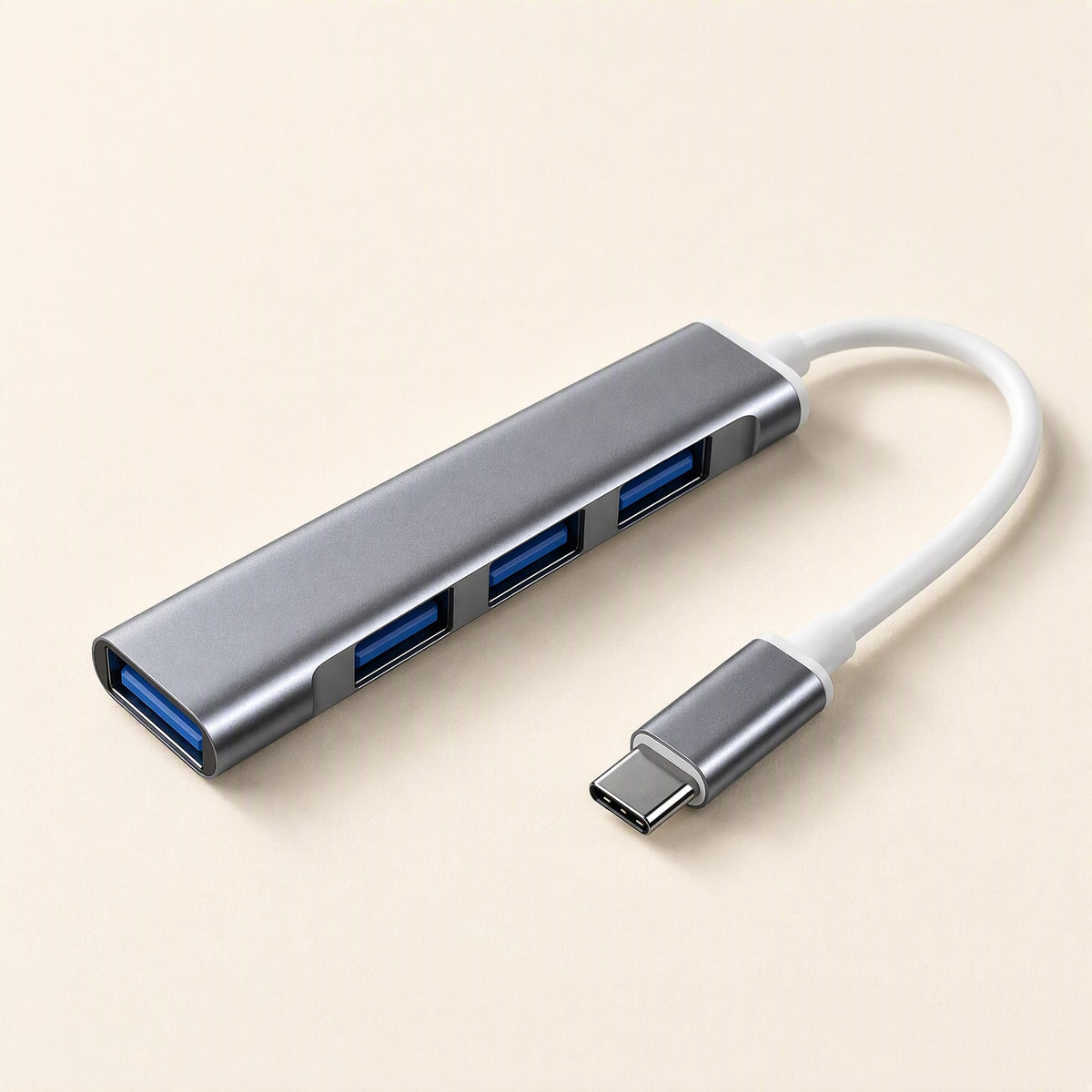 Metalbay – Space gray four-port USB hub with blue ports and white USB-C cable, angled view on a cream background