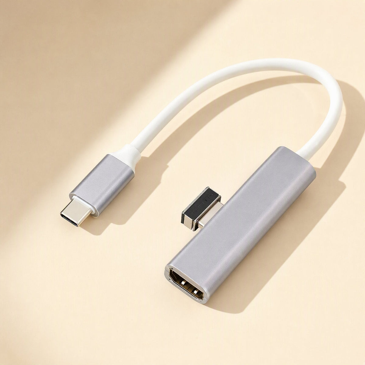 Metalbay – Gray aluminum USB-C adapter with white cable and a single HDMI port, shown on a beige surface