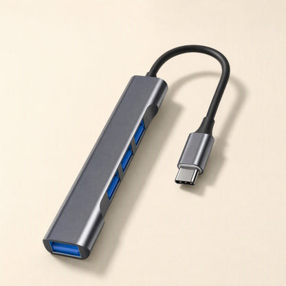 Metalbay – Dark gray slim USB hub with blue USB ports and a black braided USB-C cable on a cream background