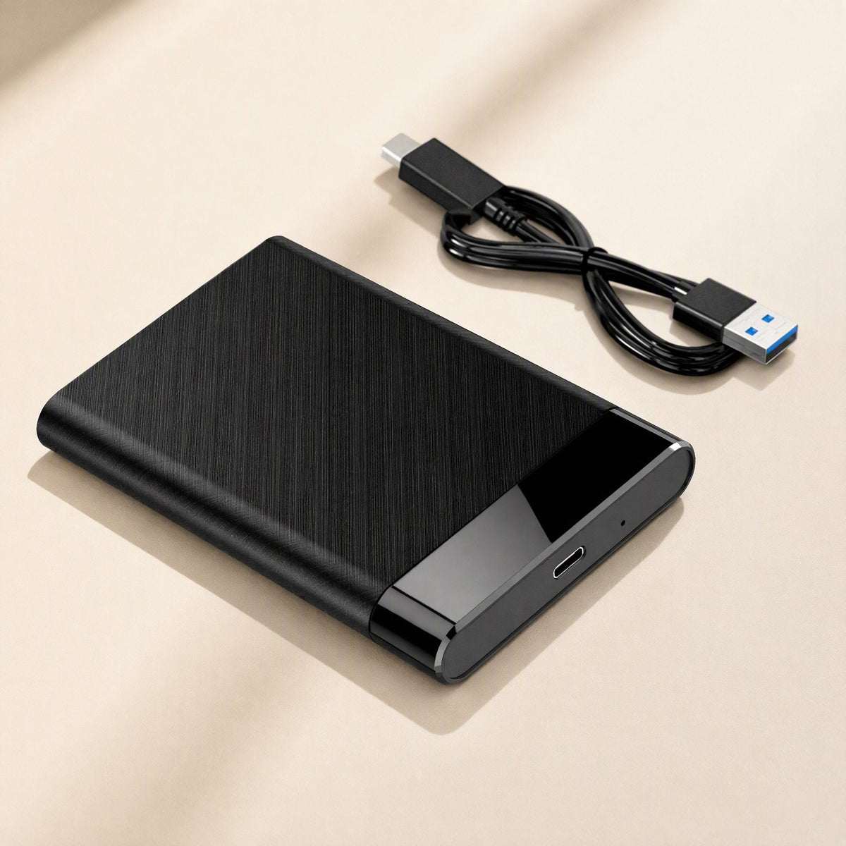 Flexshell – Brushed black enclosure with USB-C port on the end, next to a coiled USB-C to USB-A cable