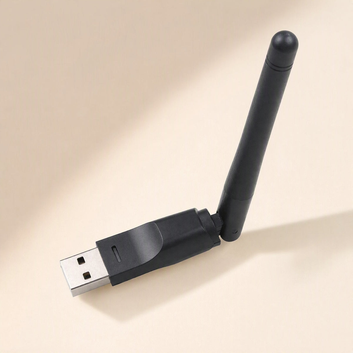 Signalstem – Black USB wireless adapter with antenna angled upward, shown on a soft beige surface