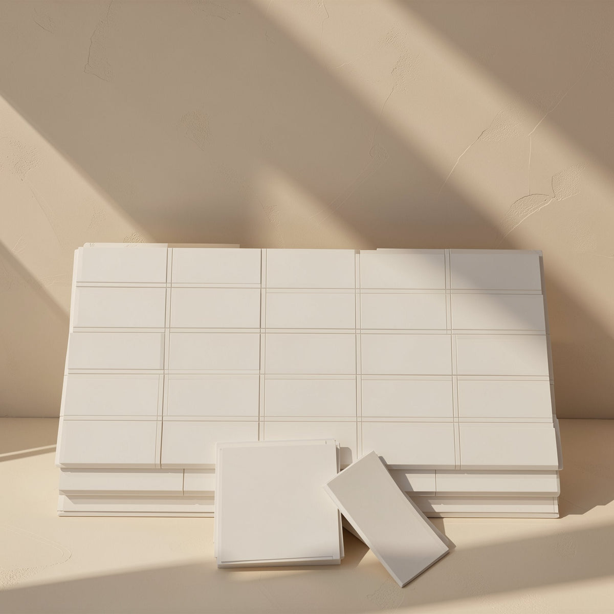 Chipchill – Stack of white scored thermal pad sheets with two cut pieces in front, against a beige wall