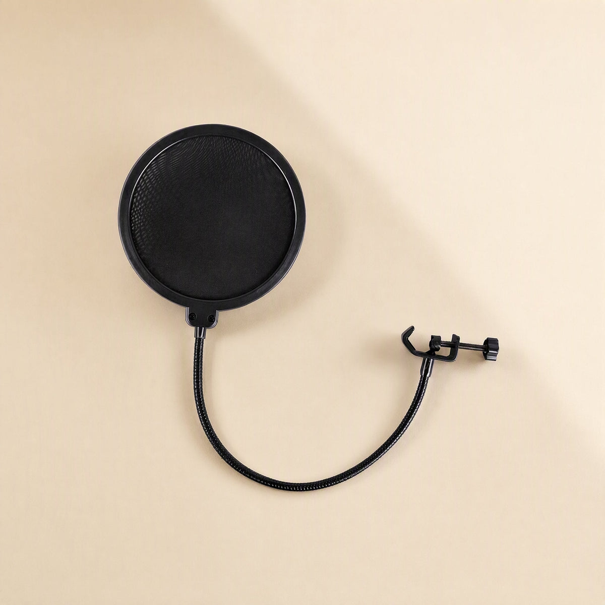 Windveil – Top-down view of the round black mesh pop filter with curved gooseneck and open clamp on a beige surface