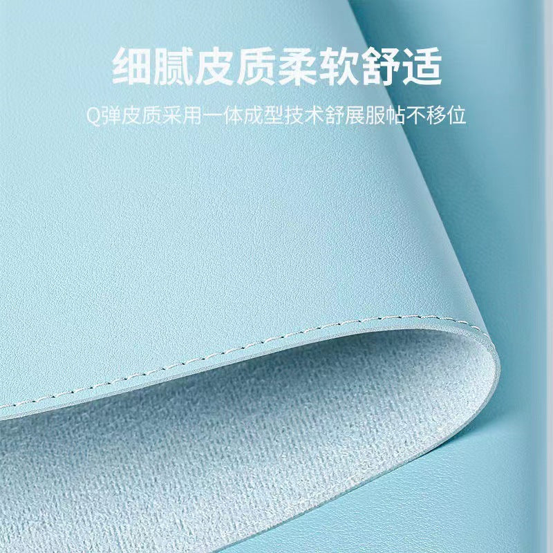 Hideloft Leather Desk Mat in light blue, curled to show white stitched edge and suede-textured underside