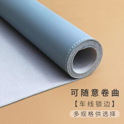 Hideloft – Blue leather desk mat rolled at one end, showing grey felt backing and stitched edge, on a tan surface