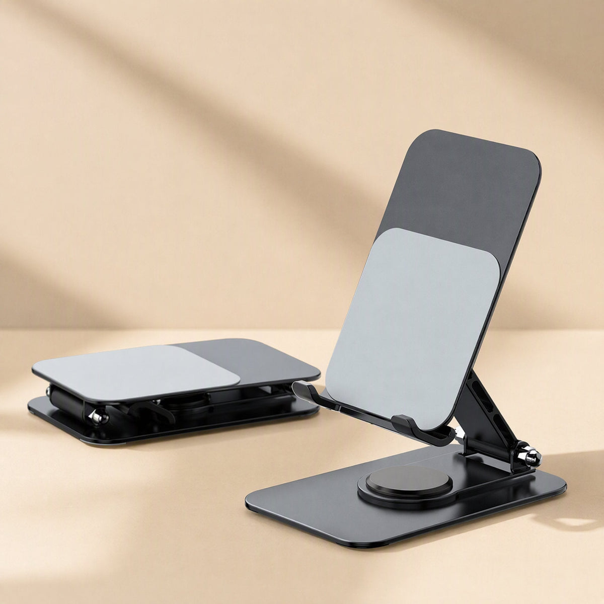 Tiltledge Desktop Phone Stand upright with swivel base beside a second stand folded flat on a beige backdrop