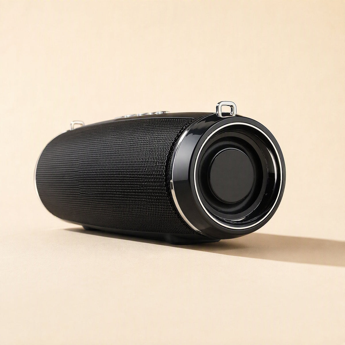 Strapsonic – Black cylindrical speaker with silver-trimmed driver ring and metal strap loops, angled front view