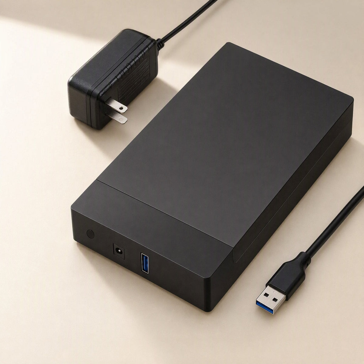 Satavault 3.5-Inch SATA Hard Disk Enclosure in black with power adapter and USB 3.0 cable on a beige surface
