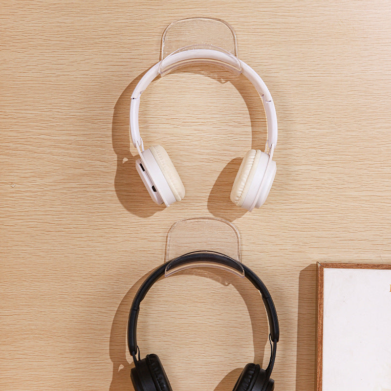 Hooksound – Two clear hooks stacked on a wood wall, white headphones on the top one and black on the bottom