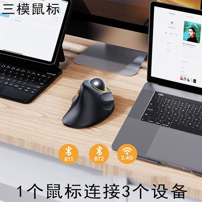 Rollbright – Black ergonomic trackball mouse on a wooden desk between a tablet keyboard and a laptop, with connection icons