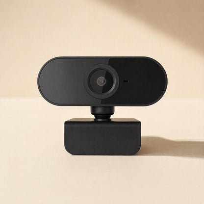 Streamface – Black webcam with glossy front and round lens, straight-on view on a beige background