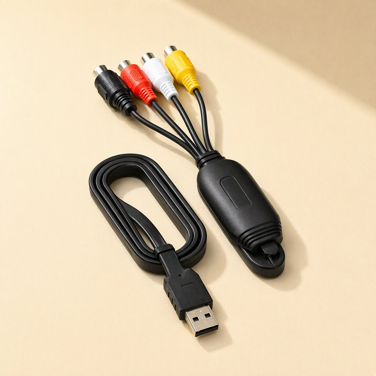 Framegrab – Capture card dongle with coiled USB cable and composite plugs, seen from above beside its USB connector