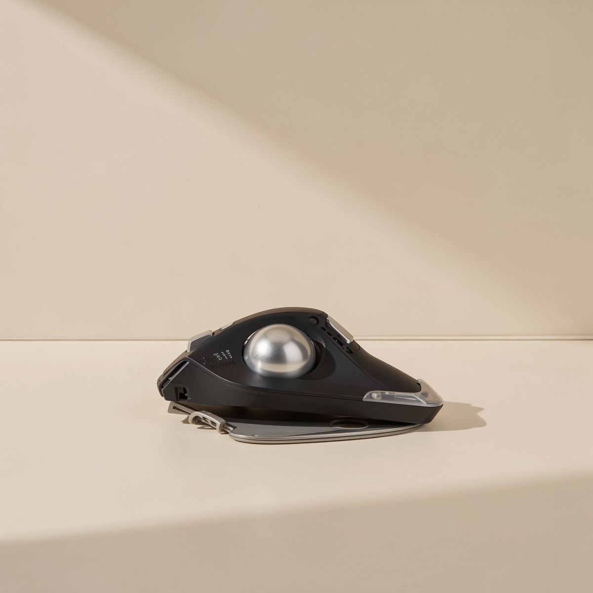 Thumbroll – Low front view of the black trackball mouse with silver ball and fold-out gray wrist support below