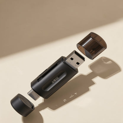Memslot – Black card reader with clear cap lifted off the USB-C end and a second cap floating beside the USB-A plug