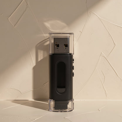Memslot TF Memory Card Reader – upright black reader with transparent cap over the USB-A connector, against a plaster wall