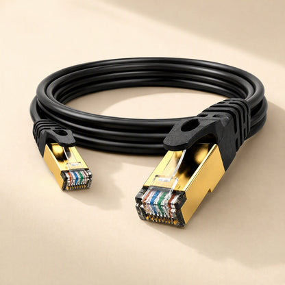 Copperlink – Black coiled CAT7 cable with gold-plated metal RJ-45 connectors and ridged strain relief boots, side view
