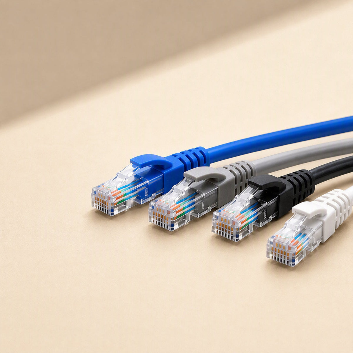 Fastlink – Four coloured RJ45 patch cables with clear plugs lined up in a staggered row, angled side view