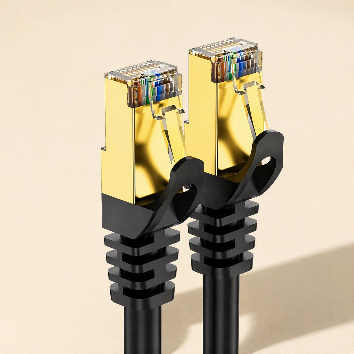 Fastlink – Pair of gold shielded RJ45 plugs with black boots on black Cat7 cables, seen from a slightly lower angle