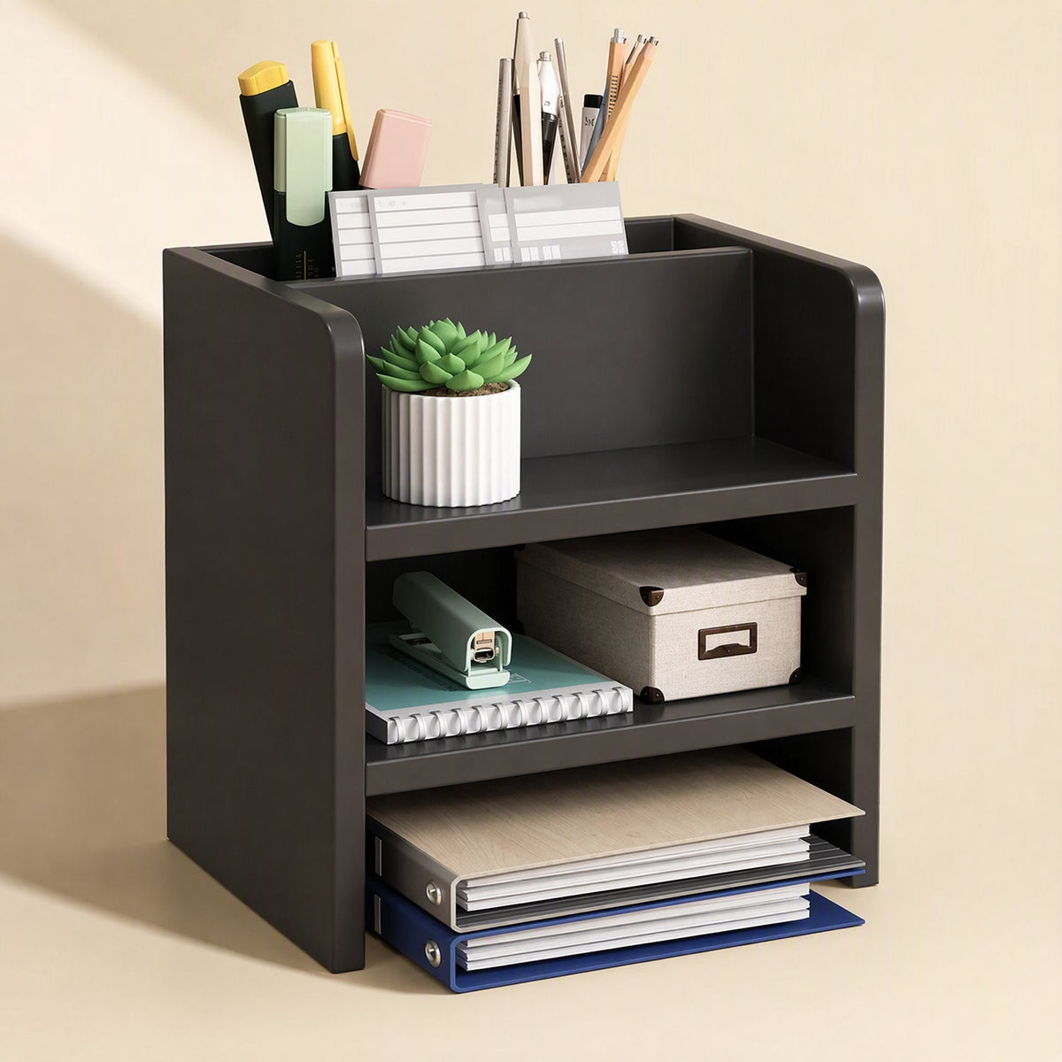 Shelfraise – Black two-tier organizer unit holding pens, a succulent, a storage box, notebooks and binders