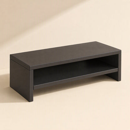 Shelfraise – Black monitor riser with an open lower shelf, shown from a front-left angle on a beige background