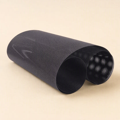 Netshield PVC computer case dust filter net, black mesh sheet loosely rolled on a cream background