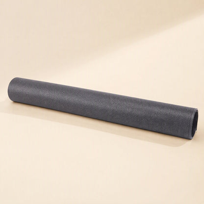 Netshield – Black mesh dust filter sheet tightly rolled into a long cylinder, shown lying flat on a beige surface