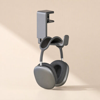 Spinrest Headphone Stand – headphone stand clipped to a desk edge with dark over-ear headphones hanging below the curved hook