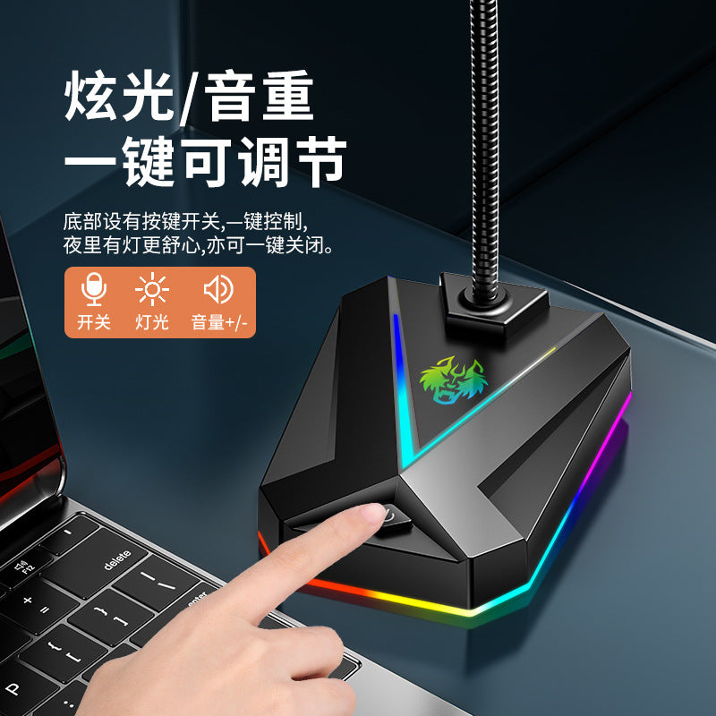 Micvox – Finger pressing the button on the angular black base with RGB light strip, next to a laptop keyboard
