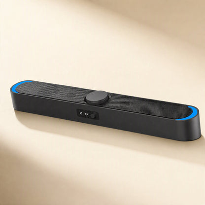Desksonic USB Desktop Small Speaker, black soundbar with blue end lights, angled view on a beige surface