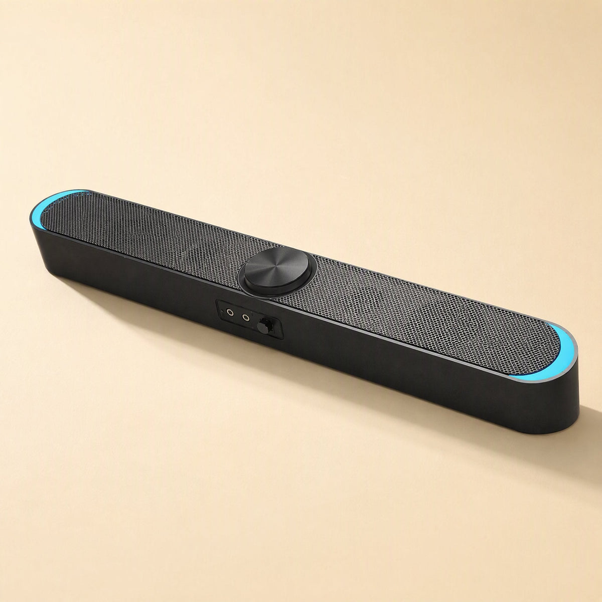 Desksonic – Front-angled view of the black speaker with light blue end glow, center dial and two jacks beside a switch