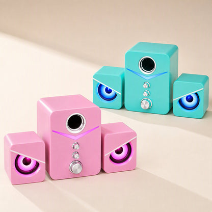 Soundbud small USB computer speaker set in pink and teal, each with glowing LED eye-shaped speaker grilles