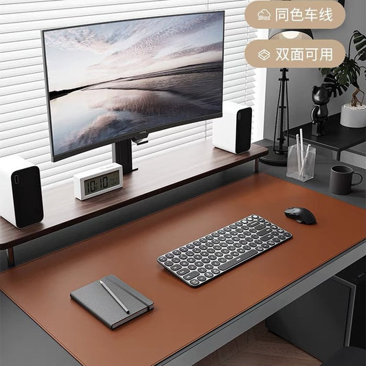 Hidelock – Brown leather desk pad under a keyboard, mouse and notebook on a desk with a monitor and speakers