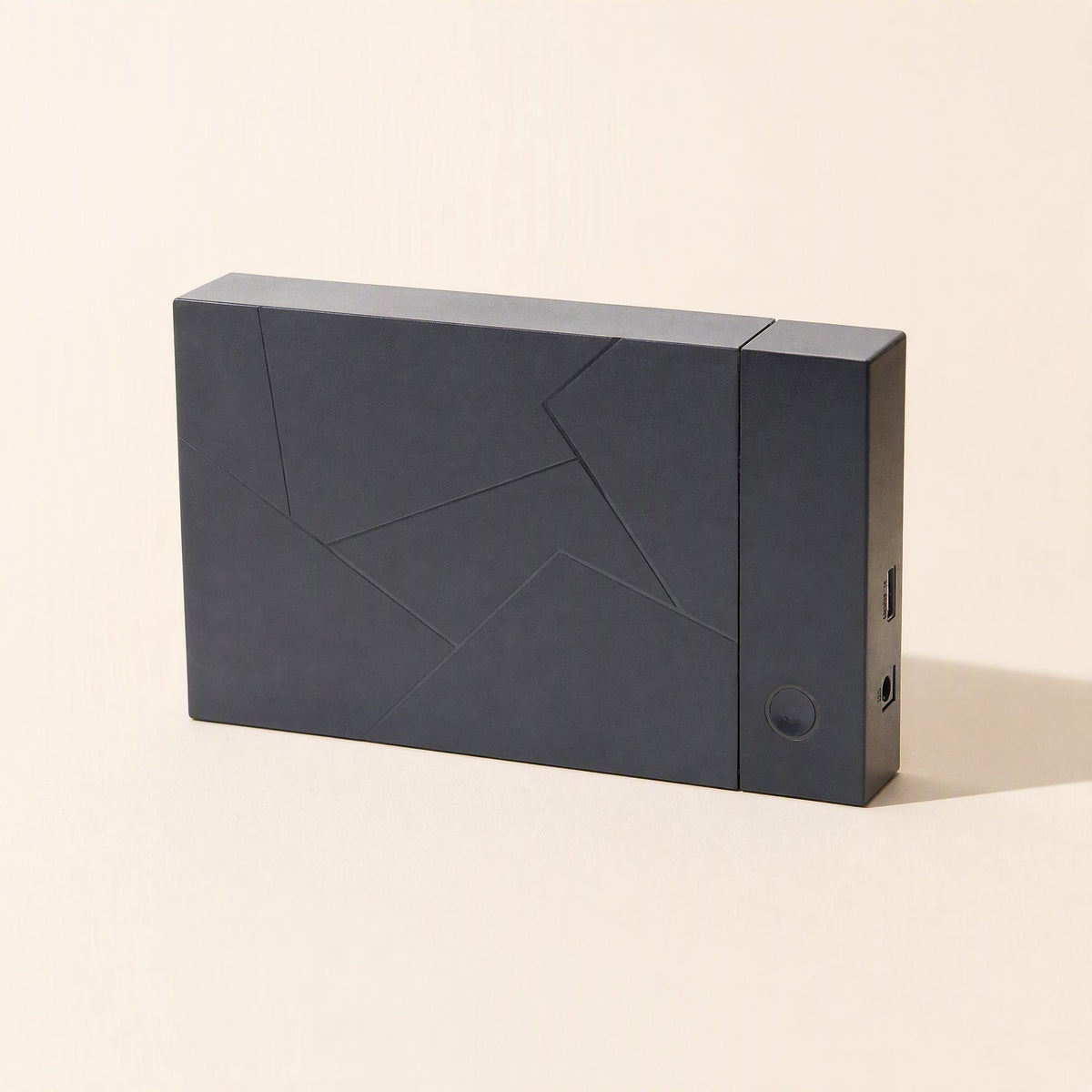 Diskbox – Black enclosure standing on its side with angular line pattern, round power button and ports on the end panel